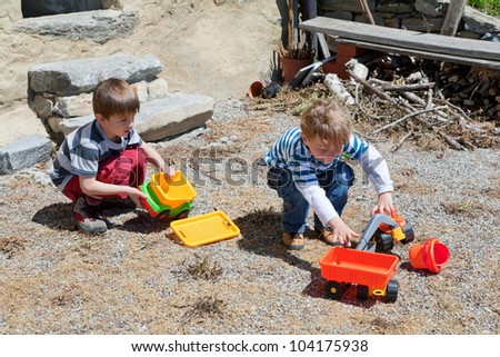 Two boy play outdoor with toys