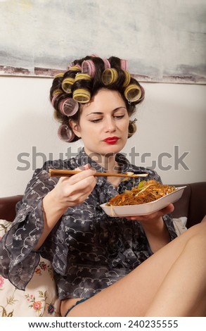 portrait of a girl with food takeaway, sitting on the sofa