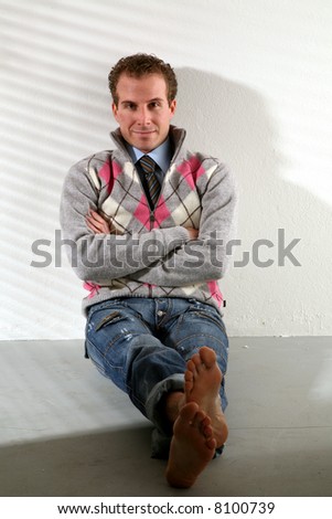Portrait of a casual young satisfied man sitting relaxed