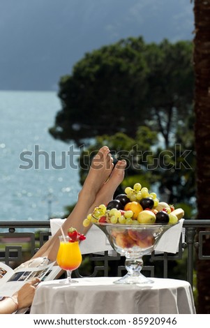 portrait of beautiful woman on the terrace, feet on the table