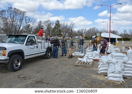 MACHESNEY PARK, IL - APRIL 20:High school students volunteer to help a flood victim load sandbags on to his pickup truck. April 20, 2013 Machesney Park, IL