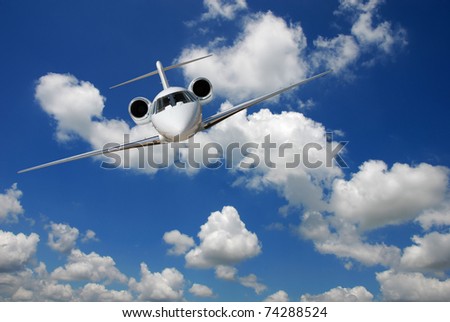 Private jet against blue sky and clouds