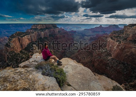 Hiker looking down Cape Royal Overlook Grand Canyon North Rim Dramatic Sunset Clouds