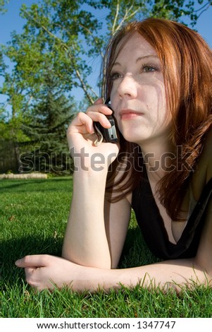 An attractive young woman converses on her cellular phone.