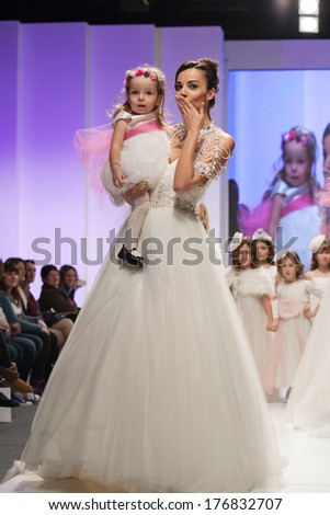 ZAGREB, CROATIA - FEBRUARY 15, 2014: Fashion model in wedding dress with child model dressed as little bridesmaid on 'Wedding days'