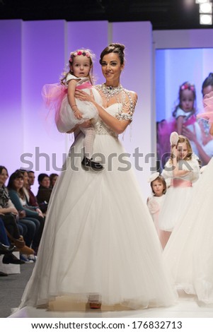 ZAGREB, CROATIA - FEBRUARY 15, 2014: Fashion model in wedding dress with child model dressed as little bridesmaid on \'Wedding days\'