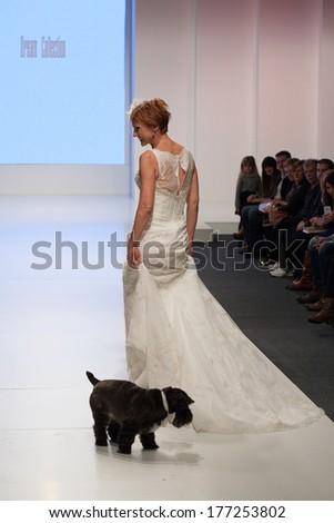 ZAGREB, CROATIA - FEBRUARY 15, 2014: Middle aged fashion model in wedding dress with a dog on \'Wedding days\' show