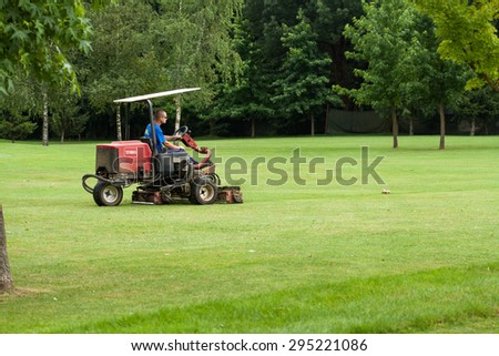 ZAPRESIC, CROATIA - JULY 09, 2015: Golf course worker mows the grass of a green in the early morning on a Novi Dvori golf course