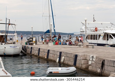 SELCE, CROATIA - JULY 24, 2015: A group of teenagers waiting for an excursion boat in Marina Selce