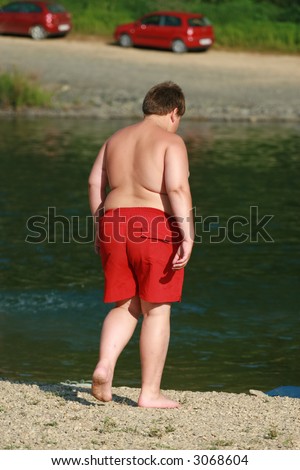 Boy on the beach with obesity problem