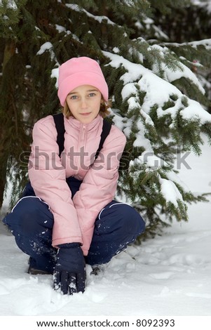 Teenage girl in pink winter clothing on the snow