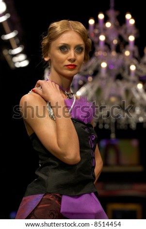 Fashion model posing under a runway lights