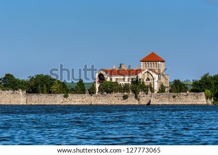 Small castle on the shores of a lake with blue sky