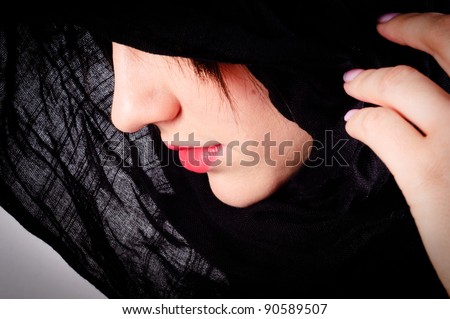 Part of a woman\'s face with black hood