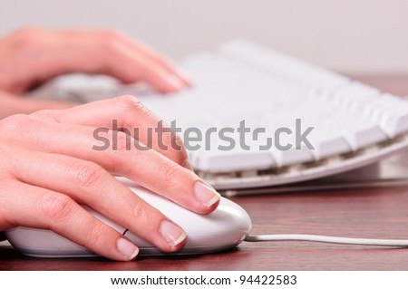 Hands of a woman using mouse and keyboard