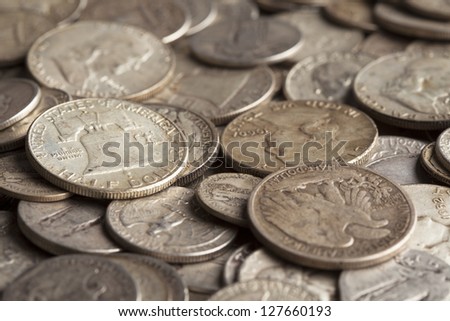 The Liberty Bell is shown on a coin pile with many other silver coins.