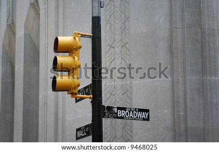 Yellow traffic light with Broadway street sign