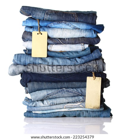 Pile of blue jeans with tags isolated on white.