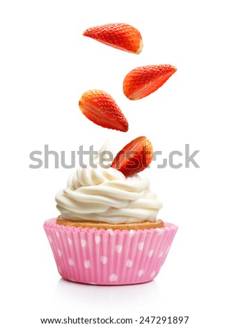 Sweet dessert, cupcake  with butter cream and falling strawberry isolated on white background.