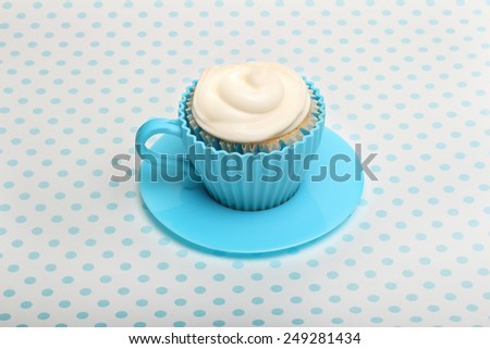 Sweet dessert, cupcake  with butter cream over spotted background.