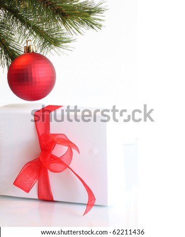 Gift box with  red bow and ribbon under  Christmas tree on white background.