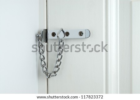 Closeup of a security chain attached to a domestic house door
