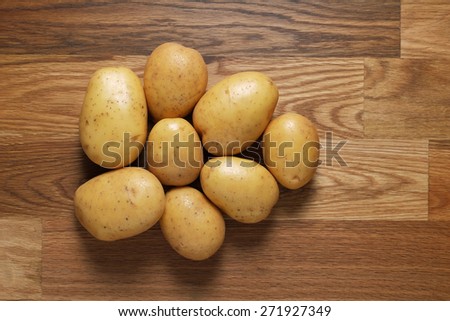 White potatoes shot from above on wooden table top