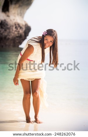 brunette bride walk out the sea water on island bay with green mountain background