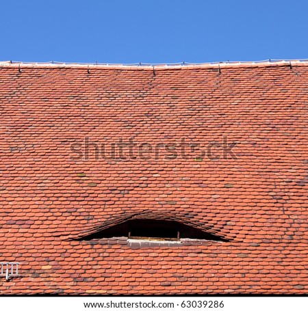 old red roof tiles and windo and blue sky