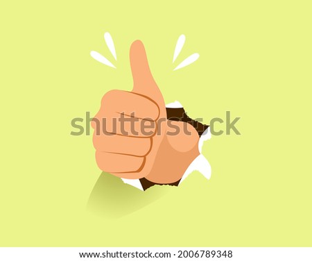 Male hand making thumb up gesture through paper hole