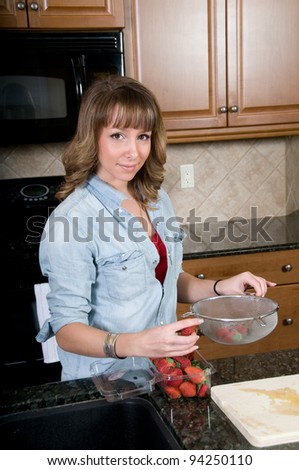 Young woman packs strawberries