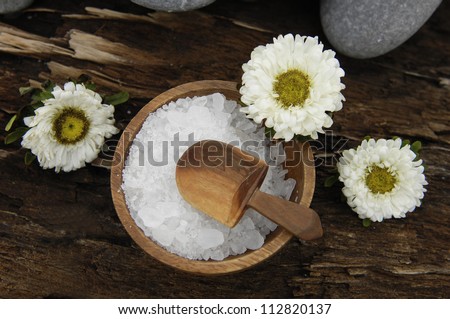 Spa concept-herbal salt in bowl and flower, green plants on old wooden