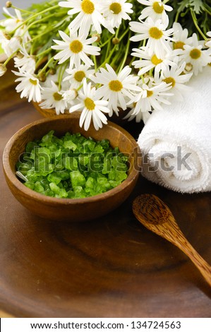 Green sea salt in wooden bowl with towel, spring flower ,towel on wooden bowl