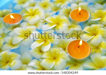 Many frangipani with three candle in the water