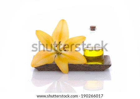 Lily and massage oil in bowl isolated on white background