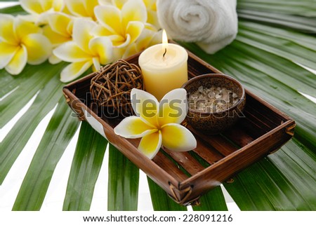 spa set with candle , frangipani flower in bowl ,towel  on green leaf