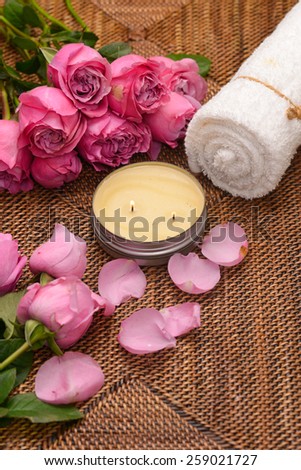 Set of rose and petals with white candle,towel on mat