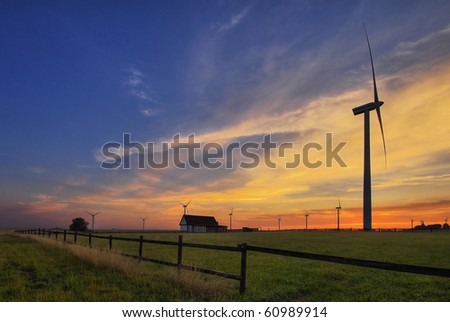 power-generating windmills on fields at sunrise