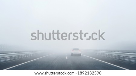 Similar – Image, Stock Photo heavy fog with bad visibility over Latvia forest country road. Dangerous partially ruined asphalt highway in misty morning