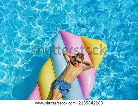 Child in swimming pool. Having fun on vacation at the hotel pool. Colorful vacation concept. Stockfoto © 