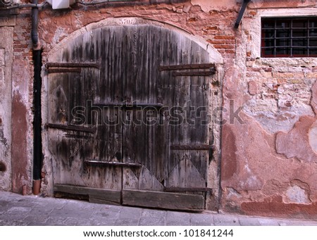 A very old large wooden double door with a large lock.