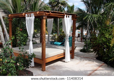 A poolside beach bed at a tropical resort.