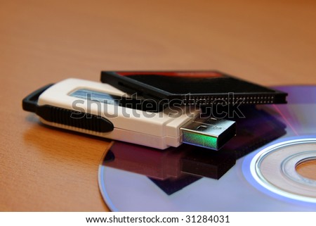 Three different pieces of media storage. (USB stick, compact flash and a DVD)