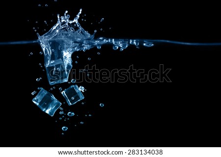 falling to the water ice cubes on dark background