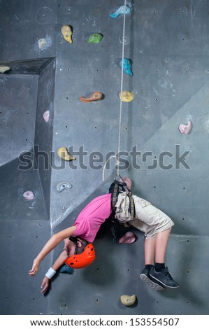 Child climbing on a wall in a climbing center. Fall of the Wall