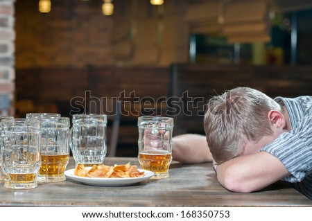 Drink responsibly. Portrait of drunk men sitting at the pub with his eyes closed