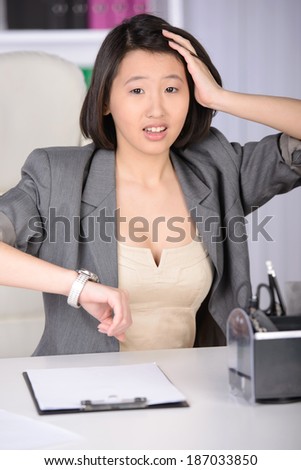 Business woman Asia, working in the office. She looks at the clock.