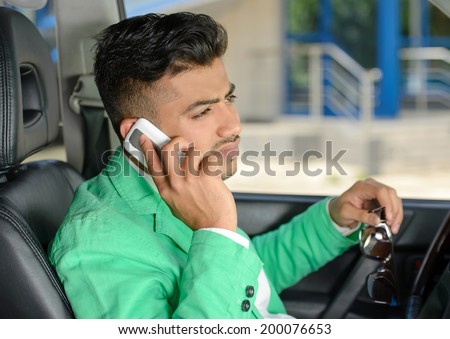Portrait of young Indian business man, driving a car