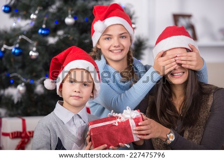 Happy family with Christmas gifts. Christmas tree and gifts in background.