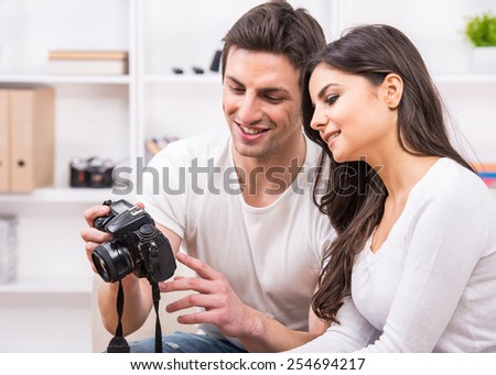 Young couple are using pc tablet to looking at photographs.